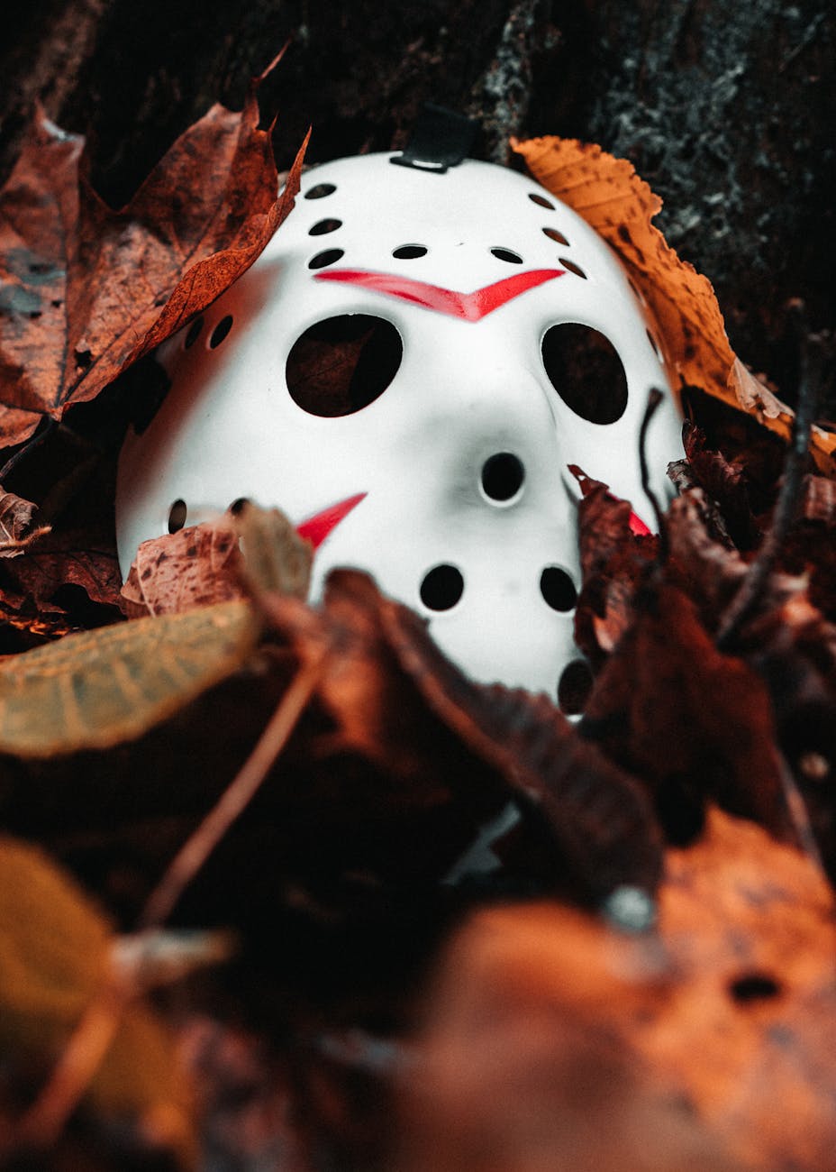 scary horror mask among autumn leaves