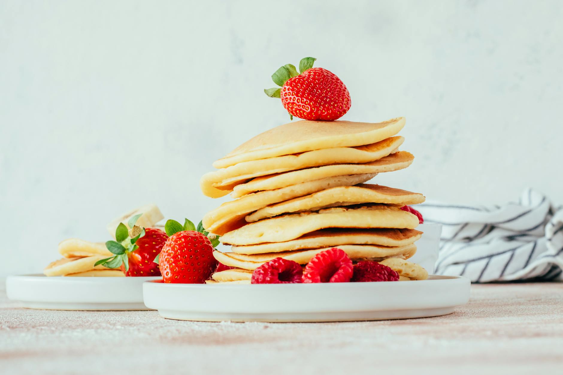 stack of pancakes with fresh strawberries and raspberries