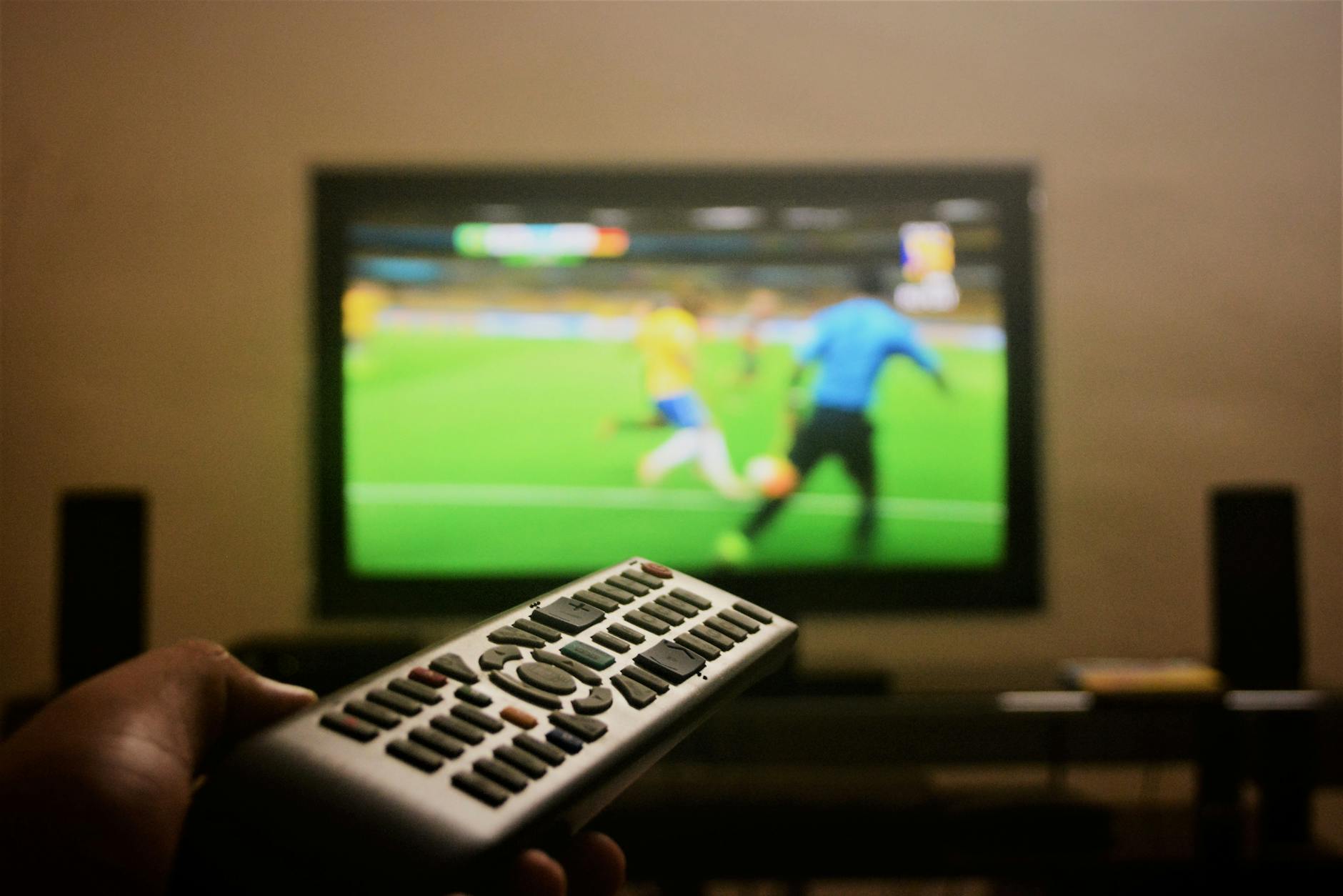photo of a person s hand holding a remote control