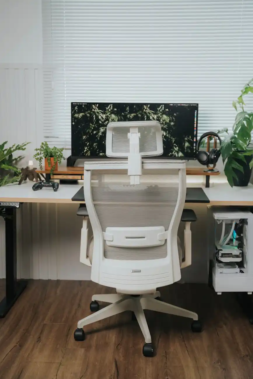 a white office chair with a plant on the desk